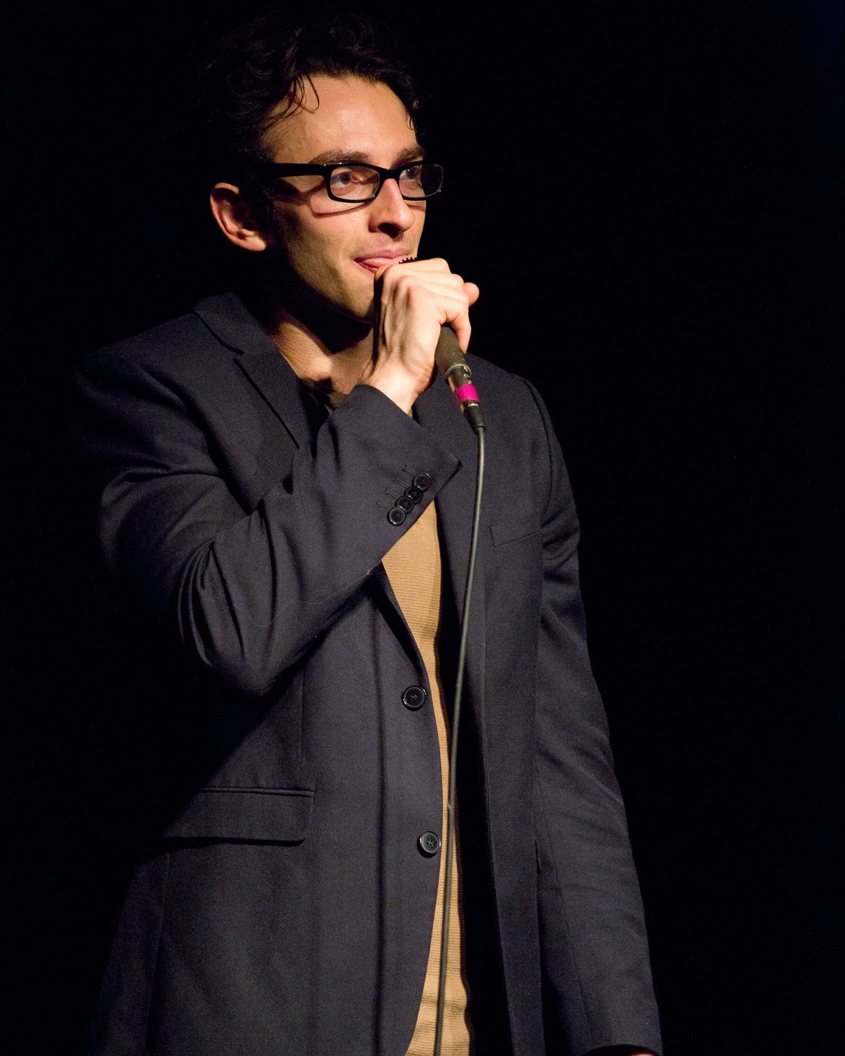 A performer alone on stage singing into a microphone in <50%